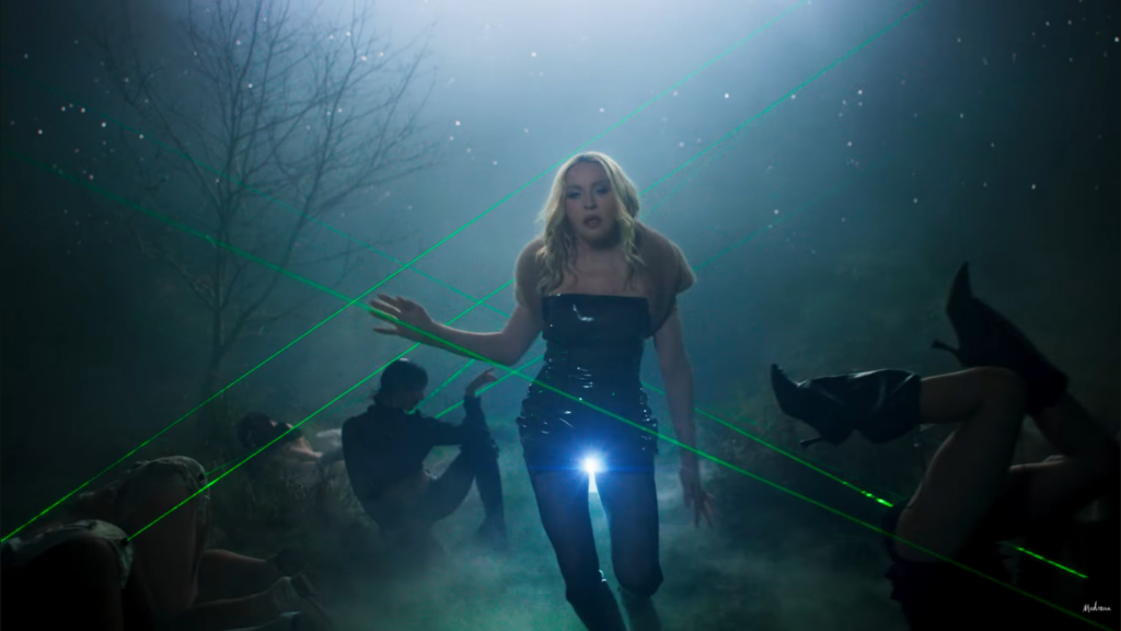 Frame de Confessions II - O Filme, minuto 1:50, Madonna com a xoxota luminosa em meio a cus de raio laser