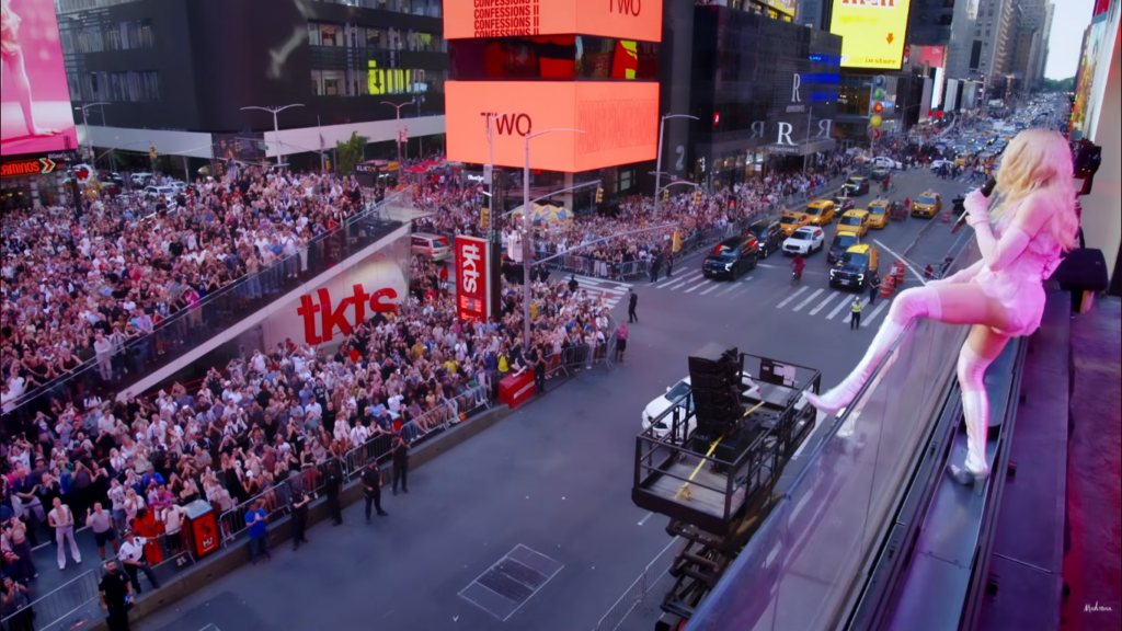 Madonna pendurada num prédio na Times Square, em Nova York, no show de Confessions II para o Mês do Orgulho.